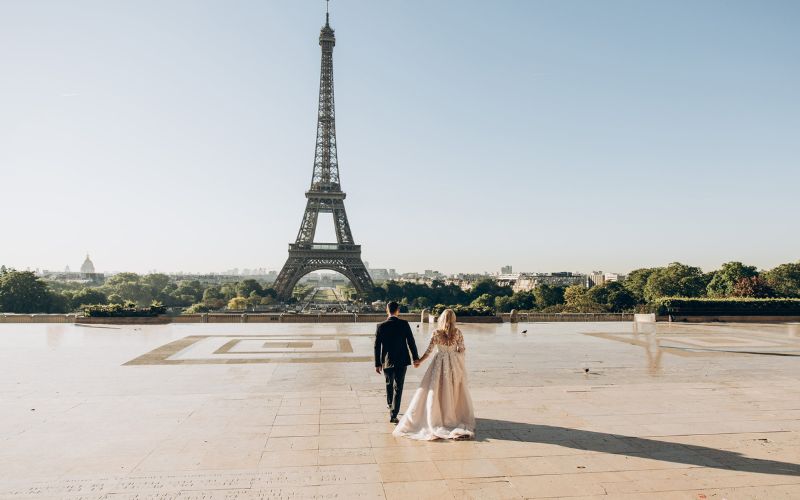 Menyasszony és vőlegény egy nagy téren, háttérben az Eiffel-toronnyal